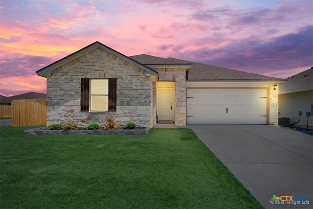 8812 Cantera Ridge Rd, Temple, TX 76502 - view of front facade featuring an attached garage, concrete driveway, stone siding, a yard, and central AC