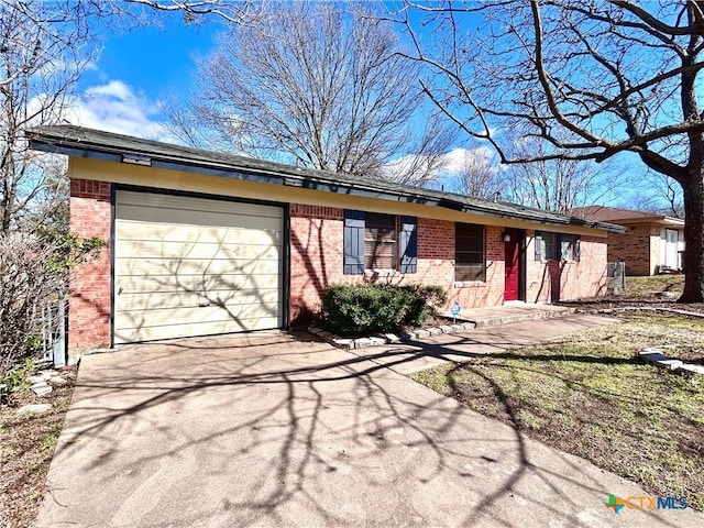 ranch-style house with an attached garage, driveway, and brick siding