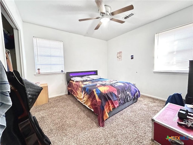 bedroom with carpet floors, multiple windows, visible vents, and baseboards