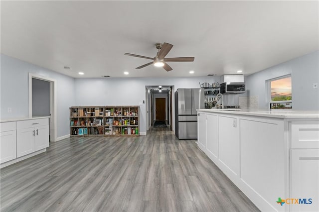 1236 County Road 7611, Devine, TX 78016 - kitchen featuring appliances with stainless steel finishes, white cabinets, a ceiling fan, recessed lighting, and light wood-type flooring