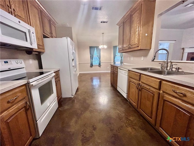 kitchen featuring light countertops, white appliances, a sink, and brown cabinets