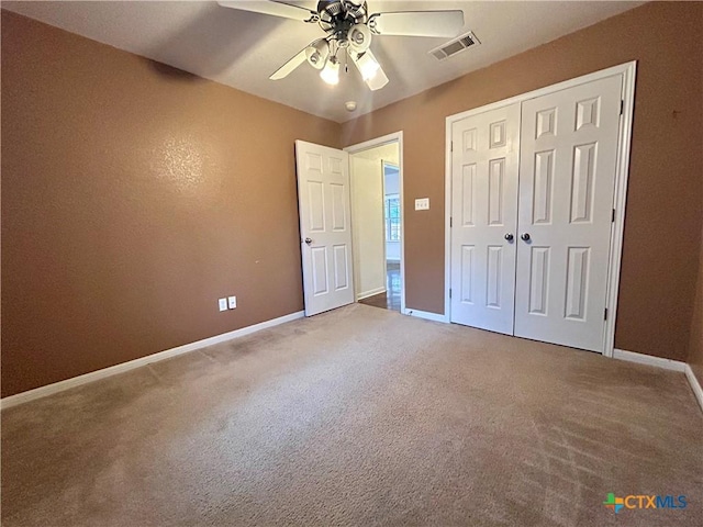 unfurnished bedroom featuring carpet, a closet, visible vents, ceiling fan, and baseboards