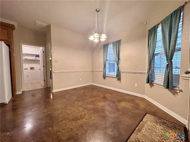 unfurnished dining area featuring finished concrete flooring, baseboards, and a notable chandelier