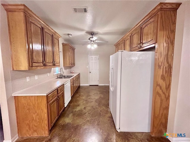 kitchen featuring white appliances, visible vents, brown cabinetry, light countertops, and a sink