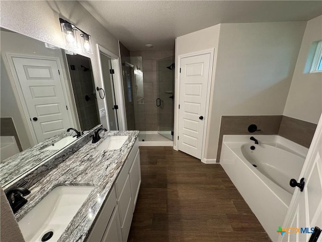 141 Atlas Ave, Killeen, TX 76542 - full bath featuring a shower stall, a garden tub, a textured ceiling, double vanity, and wood finished floors