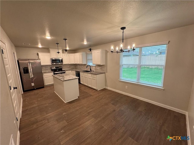 141 Atlas Ave, Killeen, TX 76542 - kitchen with stainless steel appliances, a chandelier, decorative backsplash, white cabinets, and a textured ceiling