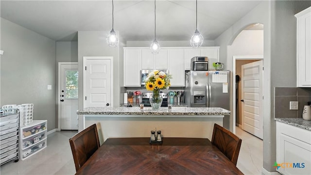 911-913 E Seideman St, Seguin, TX 78155 - kitchen featuring stainless steel appliances, light stone countertops, white cabinetry, and pendant lighting