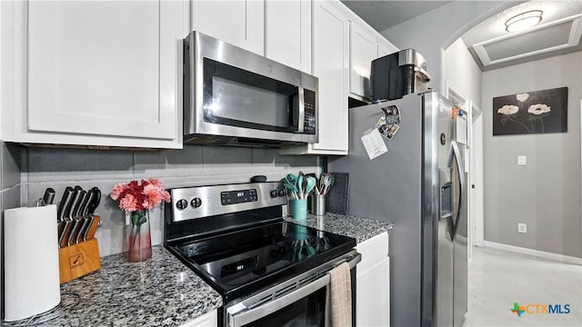 911-913 E Seideman St, Seguin, TX 78155 - kitchen featuring stainless steel appliances, white cabinetry, and dark stone counters