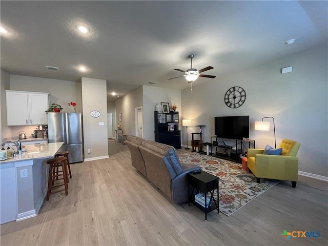 living room featuring ceiling fan and light wood-type flooring