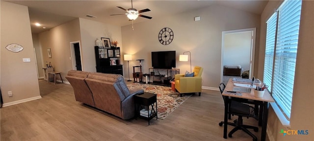 living room with ceiling fan, vaulted ceiling, and light hardwood / wood-style flooring