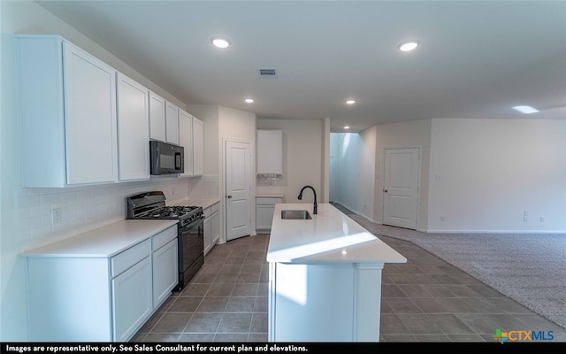 kitchen featuring white cabinets, sink, a kitchen island with sink, and black appliances