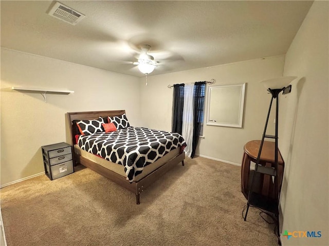 carpeted bedroom with a ceiling fan, visible vents, and baseboards