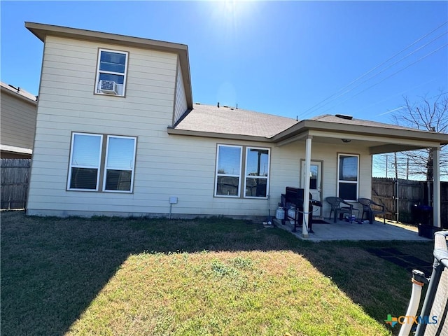 back of property with a patio, a lawn, and fence