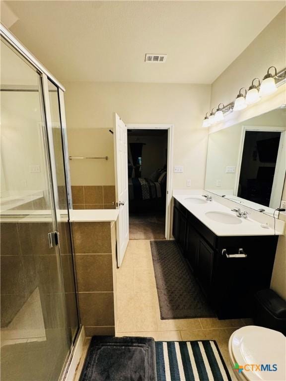 full bathroom featuring double vanity, visible vents, a sink, a shower stall, and tile patterned flooring