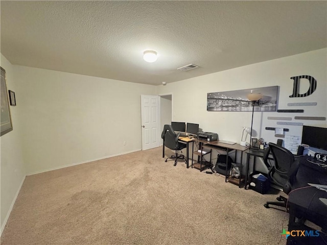 office area featuring carpet floors, baseboards, visible vents, and a textured ceiling