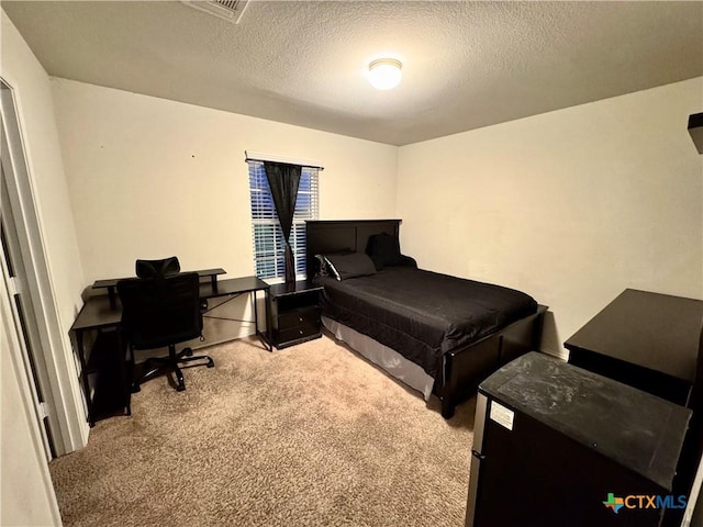 carpeted bedroom with a textured ceiling and visible vents