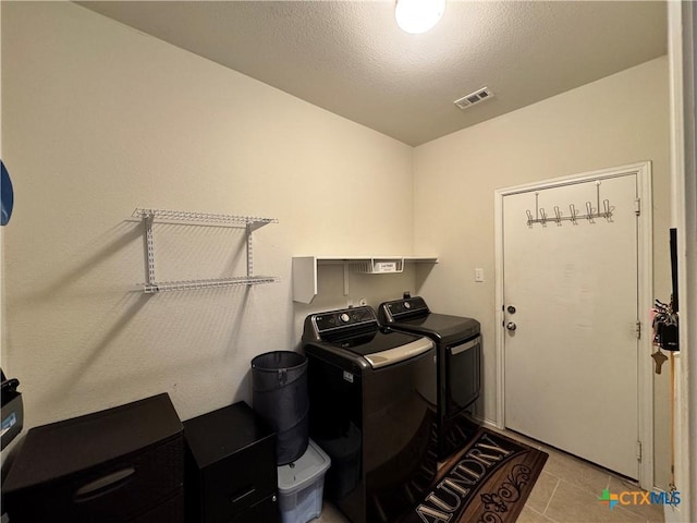 washroom with visible vents, light tile patterned flooring, a textured ceiling, laundry area, and independent washer and dryer