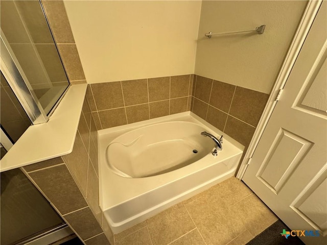 full bath featuring a bath and tile patterned floors