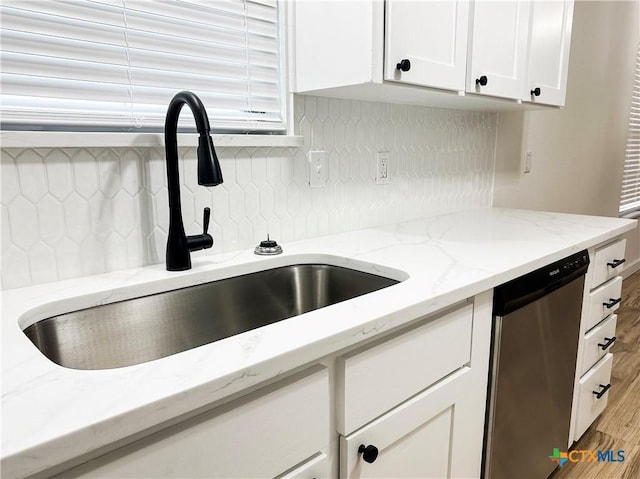 kitchen featuring dishwasher, sink, tasteful backsplash, light hardwood / wood-style floors, and white cabinets