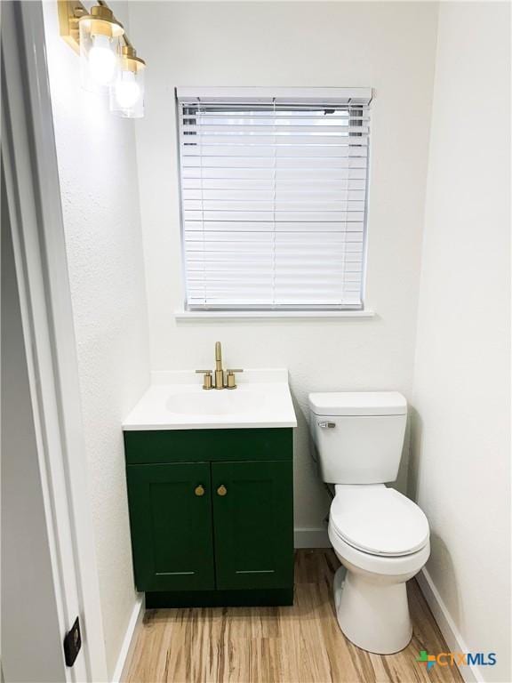 bathroom featuring hardwood / wood-style flooring, vanity, and toilet