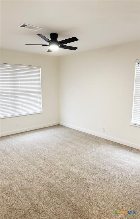 carpeted empty room featuring ceiling fan