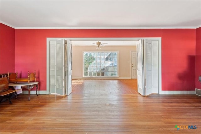 dining room featuring ornamental molding, hardwood / wood-style floors, and baseboards