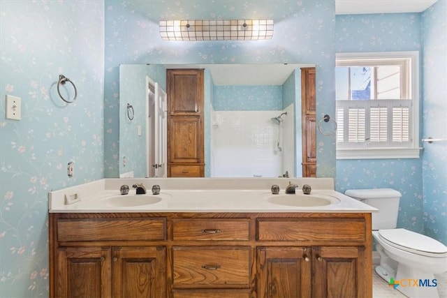 bathroom featuring walk in shower, a sink, toilet, and wallpapered walls