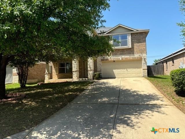 224 Starlight Dr, Temple, TX 76502 - view of front of house with solar panels, stone siding, concrete driveway, fence, and an attached garage