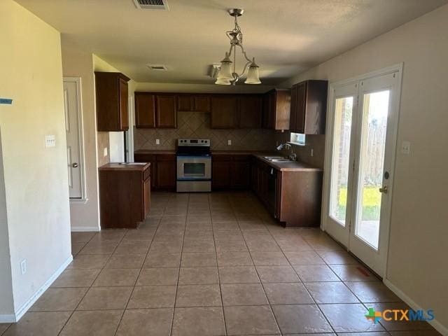 224 Starlight Dr, Temple, TX 76502 - kitchen featuring backsplash, stainless steel electric stove, light tile patterned floors, and a wealth of natural light