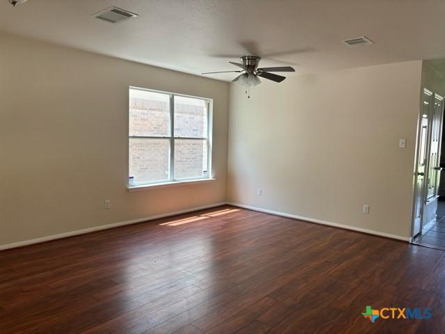 224 Starlight Dr, Temple, TX 76502 - empty room featuring baseboards, a ceiling fan, visible vents, and dark wood finished floors