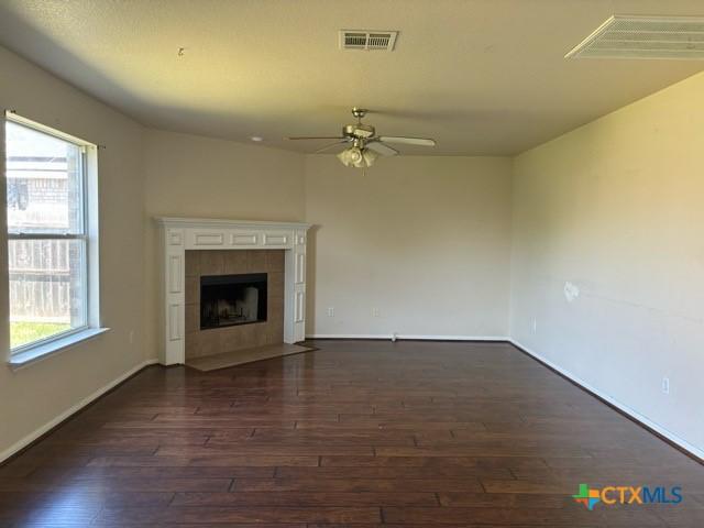 224 Starlight Dr, Temple, TX 76502 - unfurnished living room featuring a ceiling fan, dark wood-style floors, and a healthy amount of sunlight