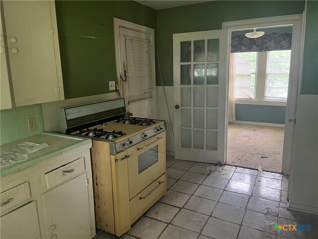 406 Lariat Ln, Victoria, TX 77901 - kitchen featuring tile countertops, baseboards, and white range with gas cooktop