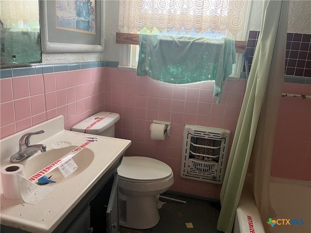406 Lariat Ln, Victoria, TX 77901 - full bathroom featuring heating unit, tile walls, and a healthy amount of sunlight