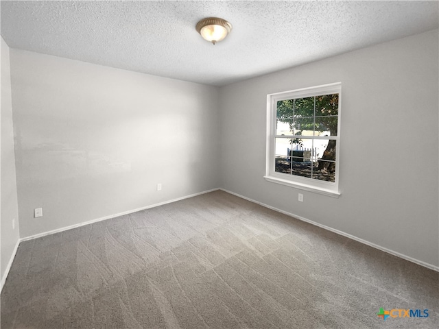 carpeted spare room featuring a textured ceiling