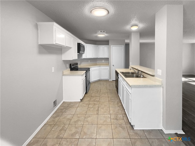 kitchen featuring white cabinetry, sink, black appliances, and a textured ceiling