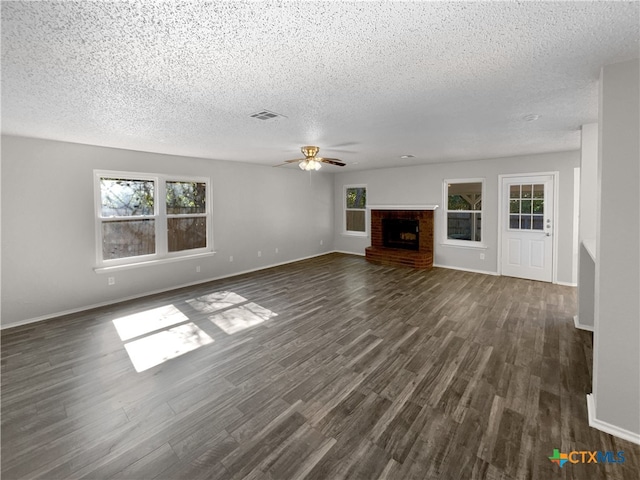 unfurnished living room with a fireplace, dark hardwood / wood-style flooring, and a textured ceiling