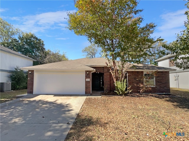 single story home featuring cooling unit and a garage