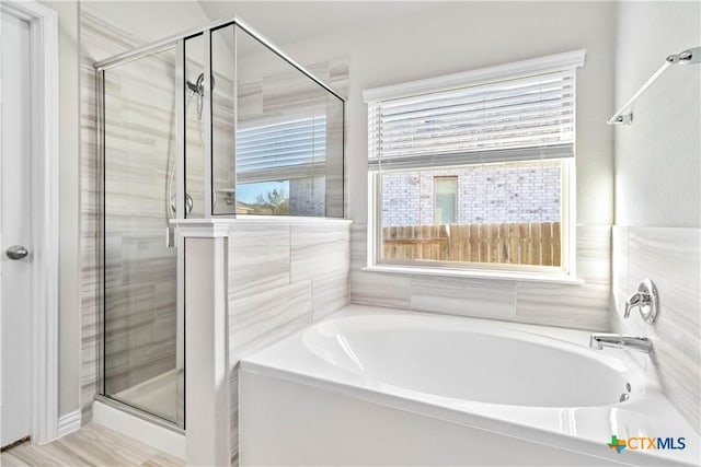 bathroom with plenty of natural light and shower with separate bathtub