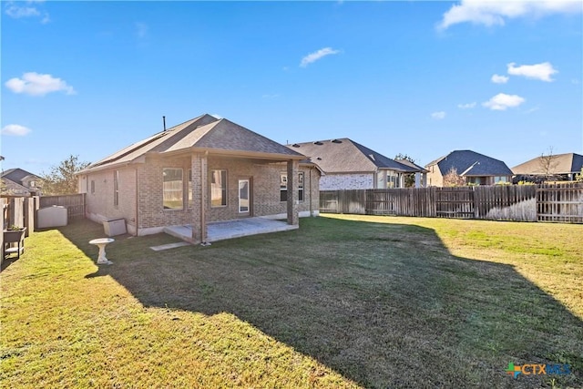 back of property with a yard and a patio area