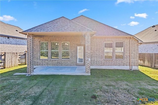 rear view of property featuring a patio and a yard