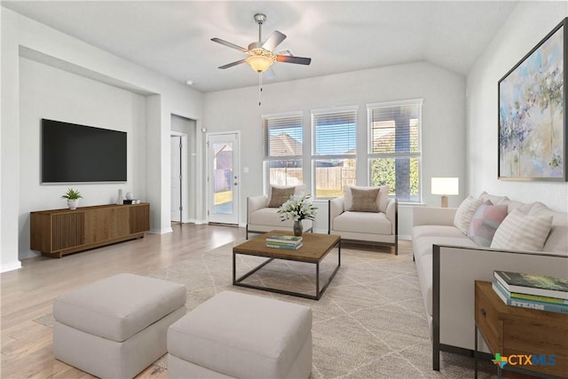 living room featuring ceiling fan, vaulted ceiling, and light hardwood / wood-style floors