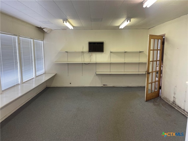 basement featuring a wall mounted AC and dark carpet