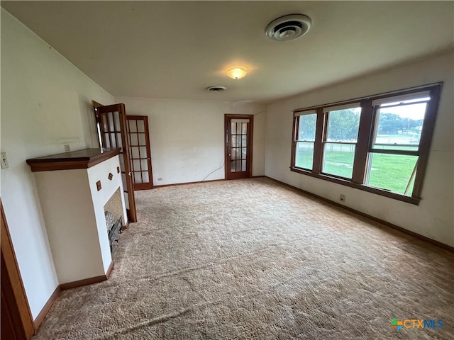 unfurnished living room with carpet and french doors