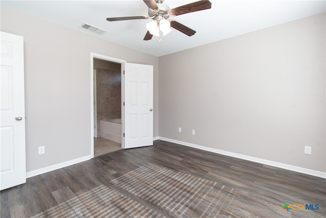 unfurnished bedroom featuring ceiling fan, dark wood-type flooring, and connected bathroom