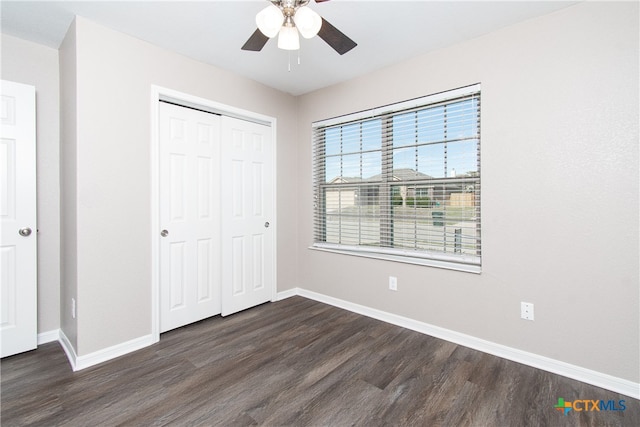 unfurnished bedroom featuring ceiling fan, dark hardwood / wood-style flooring, and a closet