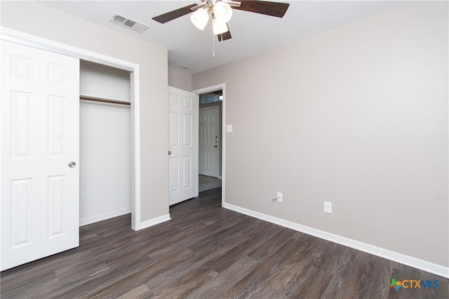 unfurnished bedroom with dark hardwood / wood-style flooring, a closet, and ceiling fan