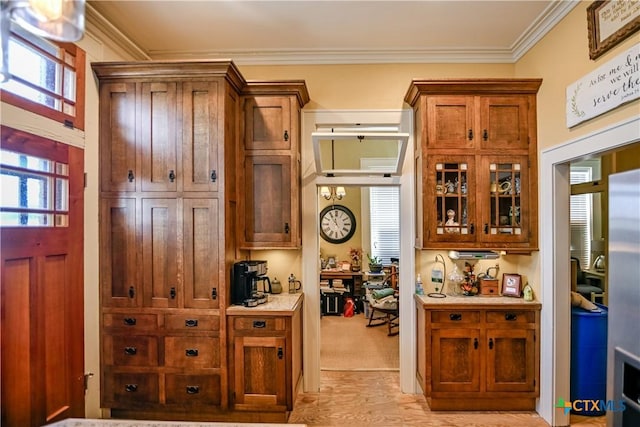 122 E Main St, Cuero, TX 77954 - kitchen with crown molding, light countertops, light wood-style floors, brown cabinetry, and glass insert cabinets