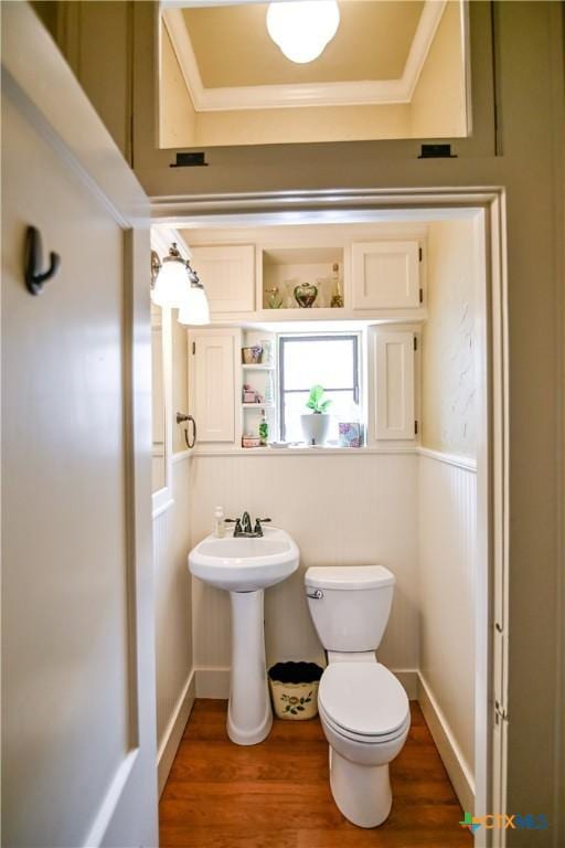 122 E Main St, Cuero, TX 77954 - half bathroom with toilet, wood finished floors, and ornamental molding