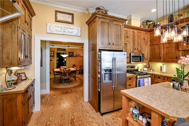 122 E Main St, Cuero, TX 77954 - kitchen with appliances with stainless steel finishes, crown molding, light countertops, light wood-style flooring, and pendant lighting