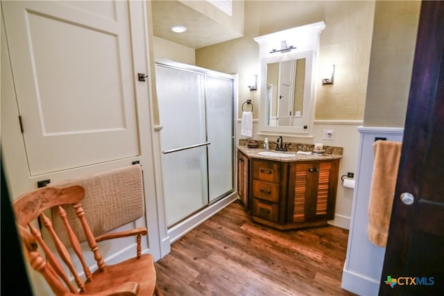 122 E Main St, Cuero, TX 77954 - bathroom with a shower stall, wood finished floors, vanity, and wainscoting